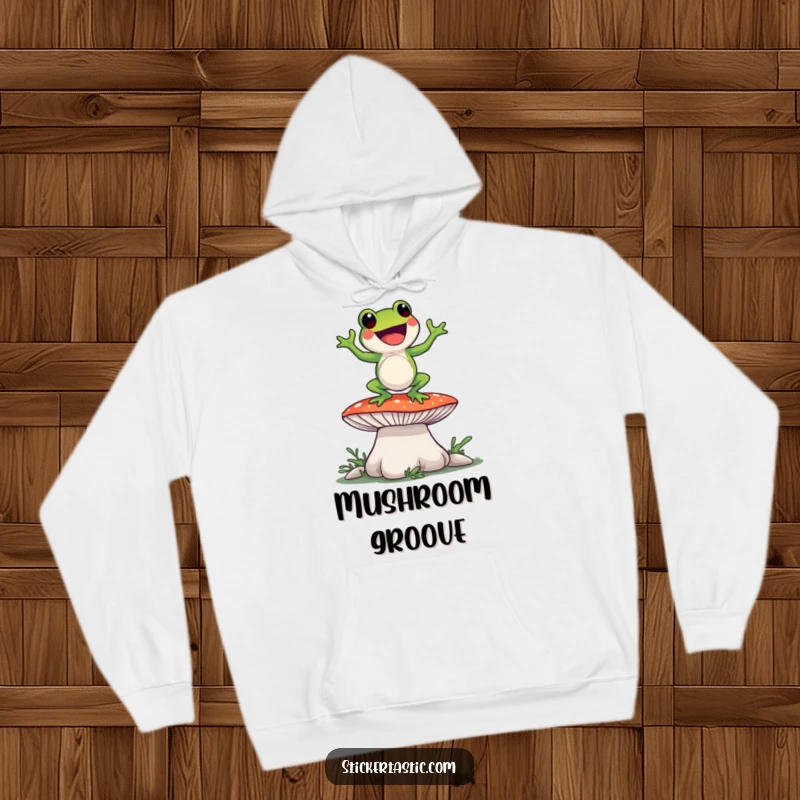 Funny frog character dancing playfully on a giant mushroom, featured on a warm, comfortable hoodie for humorous style.